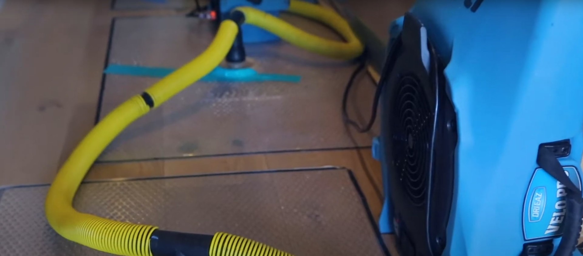 Industrial carpet cleaning and water extraction equipment in action on flooded carpet surface