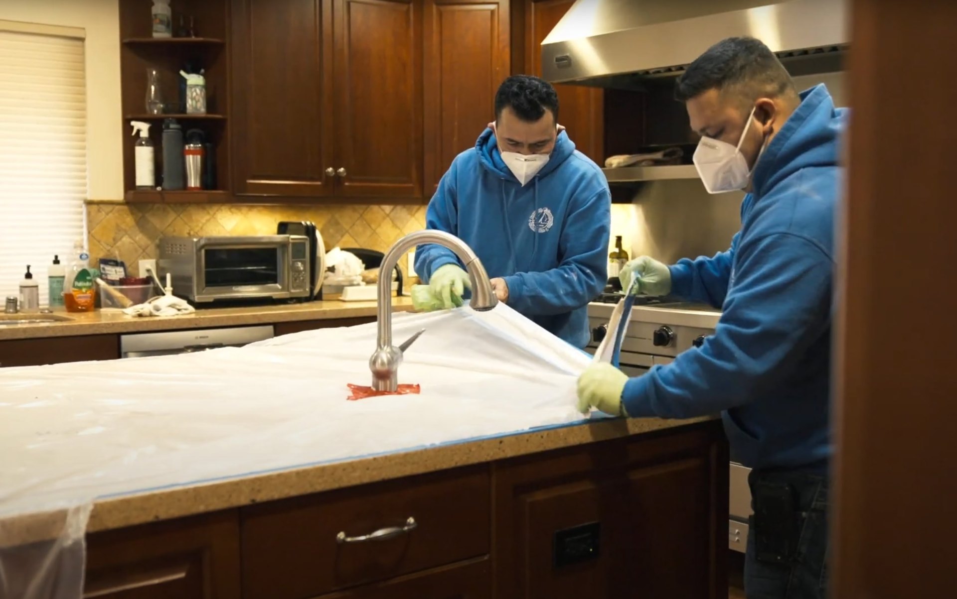 Professional water damage restoration technicians cleaning and sanitizing a kitchen after water damage